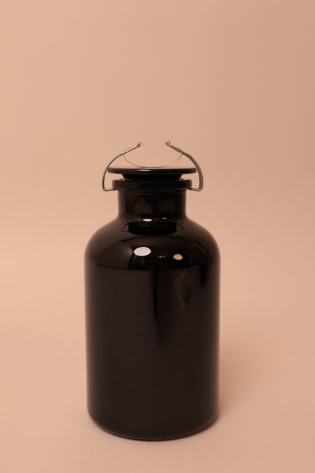 Schwarzer Metallbehälter mit einem ausklappbaren Henkel.